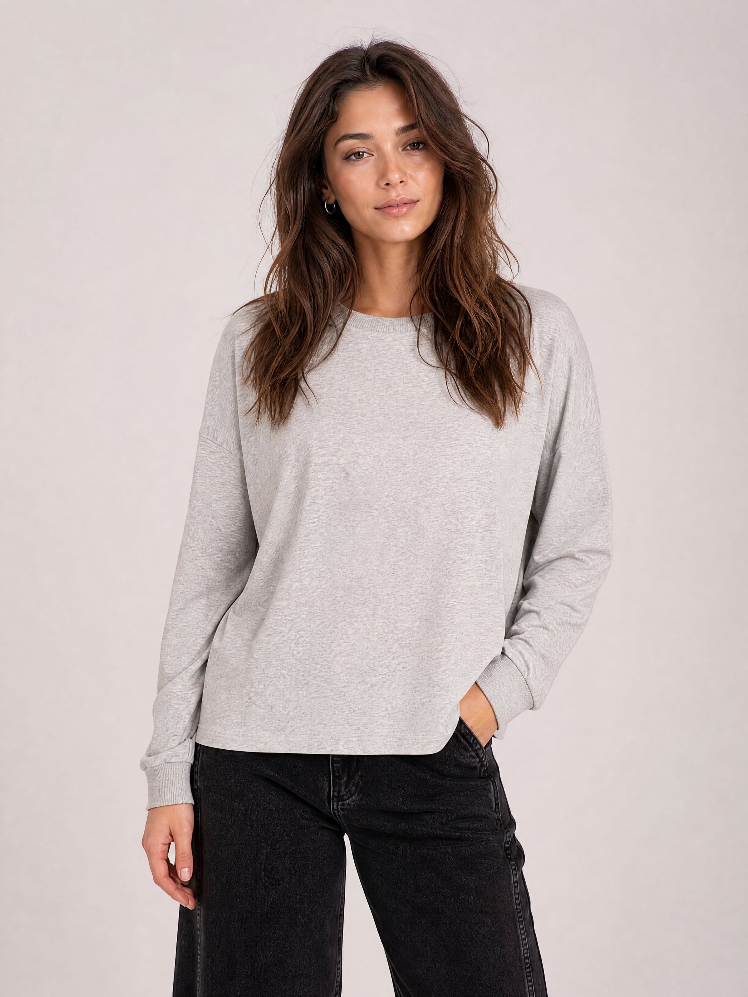 Szara bawełniana bluzka longsleeve z okrągłym dekoltem i długimi rękawami, na modelce.
